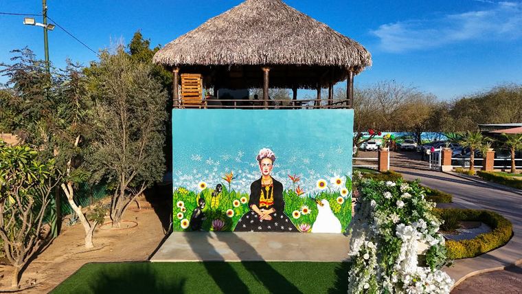Mural de mujer con flores bajo la palapa
